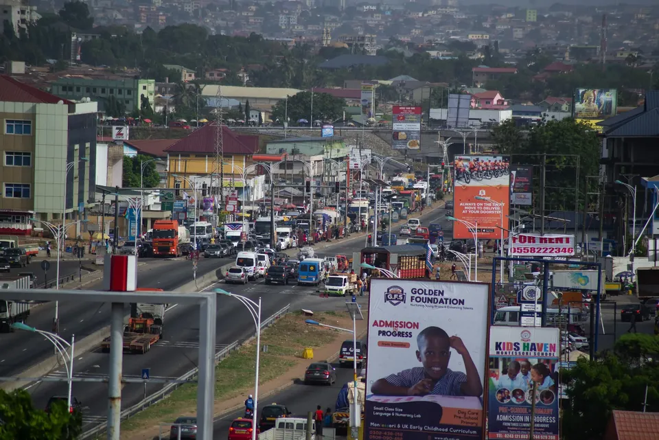 Cars waiting at a traffic light on a busy road in Achimota, Accra